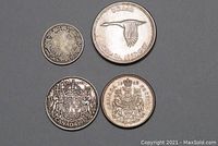 Four Canadian silver coins arranged with obverse and reverse sides showing various crests and portraits, including the 1967 silver dollar with a flying goose.