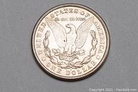 Reverse side of 1921 Morgan Silver Dollar coin showing eagle with outstretched wings, inscriptions around edges.