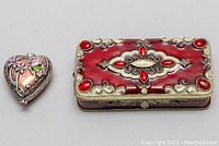 Two decorative trinket boxes and one enamel ring. Heart-shaped trinket box and rectangular trinket box with red enamel detail shown side by side with the ring.