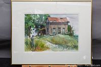 Framed watercolor painting showing old rustic house with trees and grass, 17x21 inches.