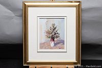 Full view of framed artwork showing gold frame and white mat surrounding centered painting of flower vase.