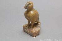 Front side view of carved puffin bird on stone base, showing detailed carving and color variation.
