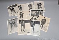 Overview of 12 vintage black and white photos showing various NHL hockey players in uniform with printed signatures
