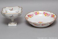 Side-by-side front view of Limoges footed dish with butterflies and round floral bowl.