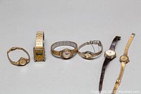 Photo showing all six ladies wristwatches arranged in a row on a white surface.