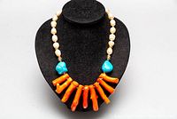 Front view of necklace showing fresh water pearls, turquoise stones, and coral branches.