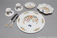 Full view of all set pieces showing cake plate, candlestick holders, spreader, fish fork, and bowls with floral and butterfly patterns