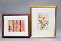 Both framed paintings displayed together: Burt Winters watercolour flower and Sharon Barr abstract acrylic.