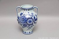 Blue and white ceramic urn with floral motifs, two handles, bulbous body