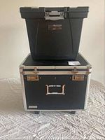 Black Vaultz rolling file case with silver hardware and programmable lock, holding black Storex portable file box on top.