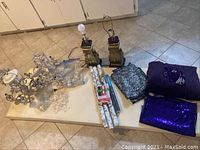 Wide view of full lot showing chandeliers, lamps, fabric rolls, and assorted craft items