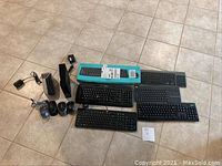 Photo showing all items: six keyboards, five mice, Hitron modem, money counter, and cables.