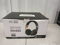 Box front showing the wireless 6S headphones with super bass, stereo folding, FM radio, MP3, noise reduction microphone, and includes cords.