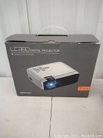 Box of Apeman LC350 digital projector with product image and LCD technology branding.