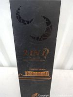 Front side of the black box showing title '2 in 1 Heating Ionic Straightener Brush' with crescent moon design.