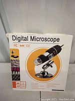 Box front showing image of digital microscope with magnification and certifications