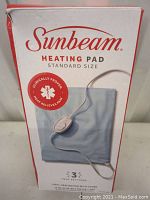 Box front showing Sunbeam branding, heating pad image, heat relief claim, and heat setting info.