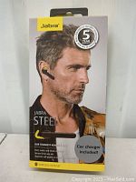 Front of the Jabra Steel wireless headset box showing a male model wearing the headset and information about 5-year warranty, car charger included, and rugged durability.