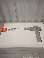 Closed white retail box labeled 'Massage Gun Therabody' with illustration of the device.
