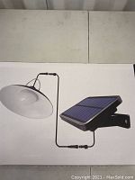 Photo showing solar motion light unit with light fixture and attached solar panel