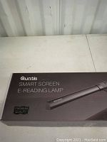 Photo of Quntis Smart Screen E-Reading Lamp box front showing product name, image and branding.