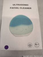 Front of the product box showing the Ultrasonic Facial Cleanser device image and control icons.