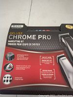 Front of box showing Wahl Deluxe Chrome Pro detailing with product features like self-sharpening blades, taper control, multi-cut clipper, precision trimmer, 6 cutting guides