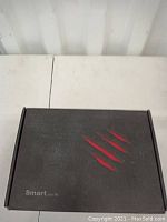 Box top with red claw mark design and Smart your life text