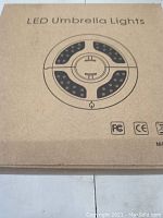 Photo of the cardboard box for LED Umbrella Lights showing an illustration of the light design with 3 LED sections in a circle.