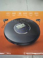 Photo of the pop-up box showing a Gueray portable CD player with control buttons, digital display, and a stylized design.