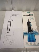 Photo of two oral irrigator boxes side-by-side, one white box labeled 'Cordless Oral Irrigator' and one labeled 'Oral Irrigator Portable DIY Mode' with product image.