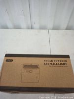 Cardboard box with label showing 'Solar Powered LED Wall Light' and brand 'Oreo'