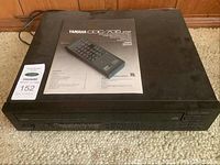 Top view of the Yamaha COC-705 CD player with instruction manual on top.