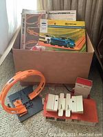 Wooden box containing boxed speedometer track and loose track pieces, launcher and collector case