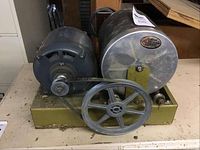 Side view of the motor and rock polisher showing belt drive and mounting base plate.