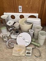 Full lot of Braun Kitchen Mix Master with various attachments and accessories including mixing bowl, blender jar, meat grinder parts, and slicer discs