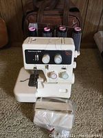 Front view of serger on carpet with case visible behind