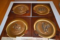 Four bronze art plates depicting Frederic Remington sculptures mounted on wood frames with certificates beneath each plate.