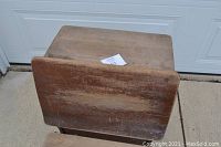 Front view of the wooden backrest and desktop of the vintage school desk showing wear and scratches.