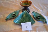 Four Blue Mountain Pottery items: two leaf-shaped candle holders, one triangle shaped dish, one pedestal bowl/candle holder