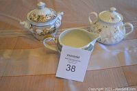 Set showing three different sugar bowls and creamers on table, including Royal Doulton Temple Garden, Mikasa Isle Jade, and Wedgwood Campion patterns