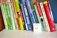 Photo showing the spines of multiple health and fitness books arranged on a shelf, including titles on diet, meditation, immune system, aromatherapy, and yoga.