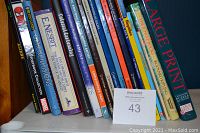 Spine view of assorted children's books including titles on illusions, manga drawing, pets, and nature.