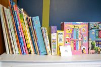 Shelf with 19 assorted children's books showing colorful covers with story and activity themes.