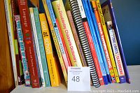 Shelved teacher reference books focusing on classroom management, arts, and language arts