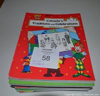 Photo of a stack of teacher resource books with the top book titled 'Canada's Traditions and Celebrations Grades 1-3'