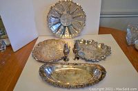 Full view of the lot showing all silver plated trays and salt and pepper shakers from a slightly different angle.