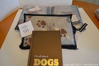 Photo showing three dog lover's kits including a black mesh zippered bag with microfiber towels printed with dog paws and bones, and a brown hardcover notebook with gold text 'I'm all about DOGS'.