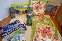 Photo showing paper plates, napkins, tiki candles, garland, and pennant banners arranged on a table.
