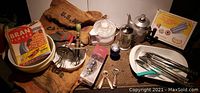 Full collection photo showing bowls, beaters, electric juicer, coffee pots, bottle openers, cookie maker, grain sacks, Bran flakes box, and utensils.